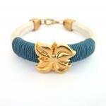  pearl white thick leather bracelet with a gold plated flower charm and dark teal waxed cotton cord details